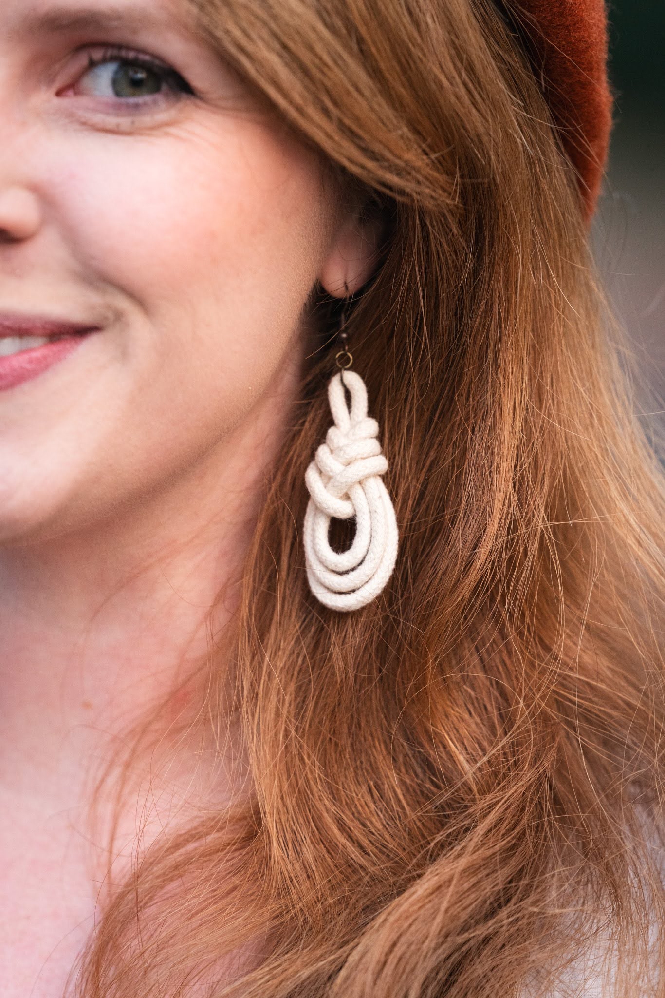 Smiling redhaired model wearing Triple Macrame Loop earrings